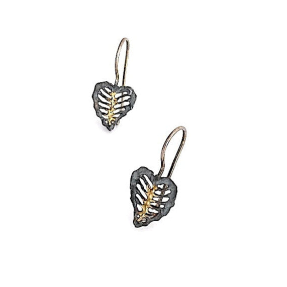 Boucles pendantes façonnées en argent patiné, elles présentent un travail d'ajourage grâce à un ciselage. Au centre, une nervure centrale est soulignée d'une touche d'or jaune. Fermeture crochet.