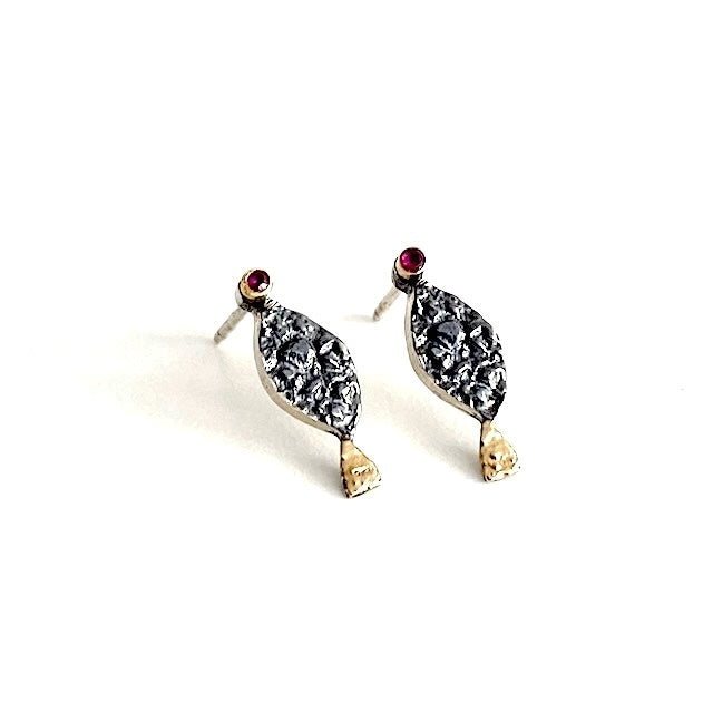 Clous d'oreilles en forme de petit poisson stylisé. La tête est ornée d'un rubis serti sur le lobe, le corps en argent patiné et texturé, la queue se pare d'or jaune.
