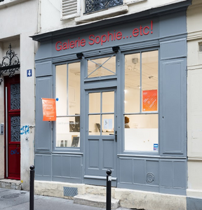 Galerie de bijoux contemporains à Paris, façade en bois gris clair, lettrage rouge.