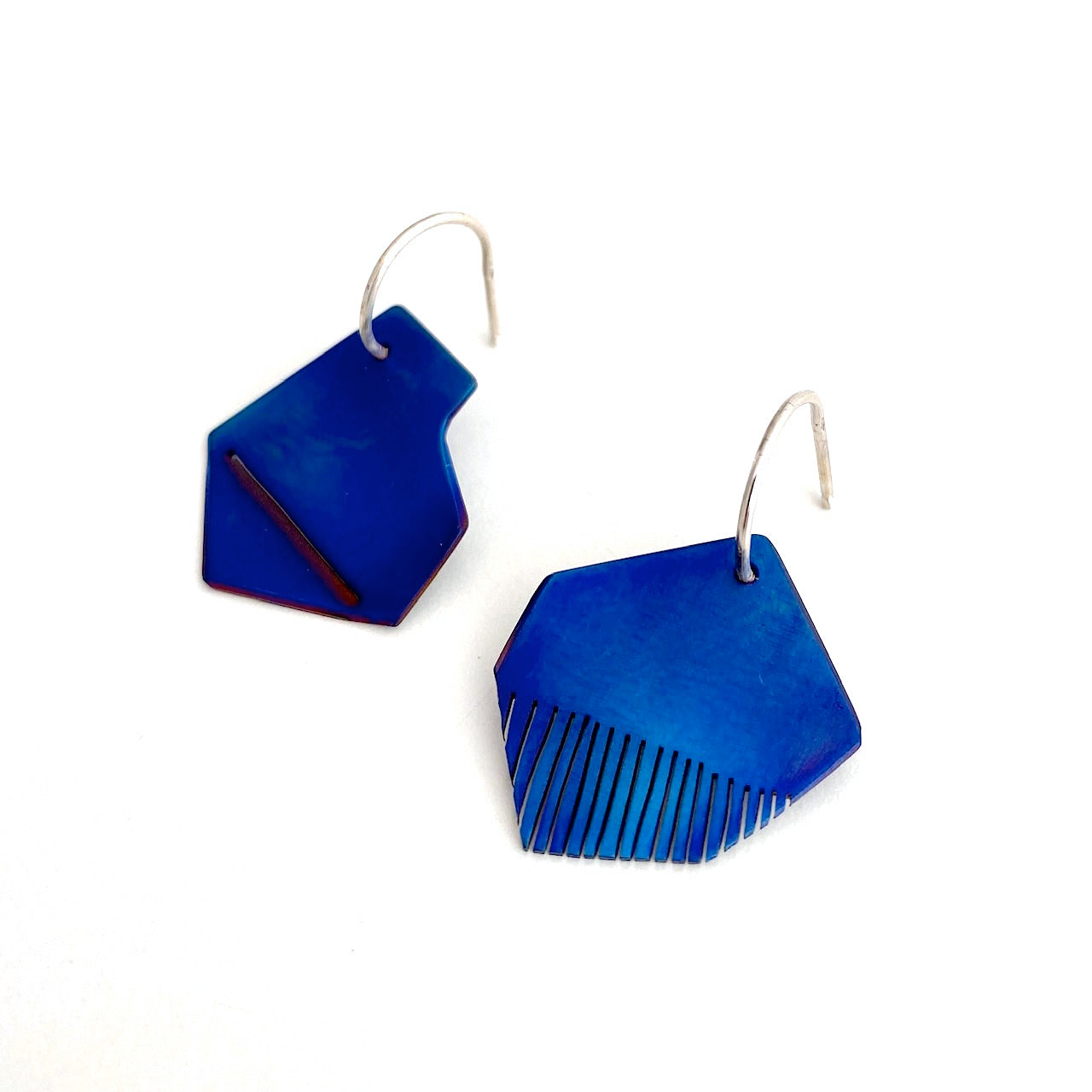 Boucles d'oreilles asymétriques en titane plié et scié bleu montées sur tiges argent forme créoles
