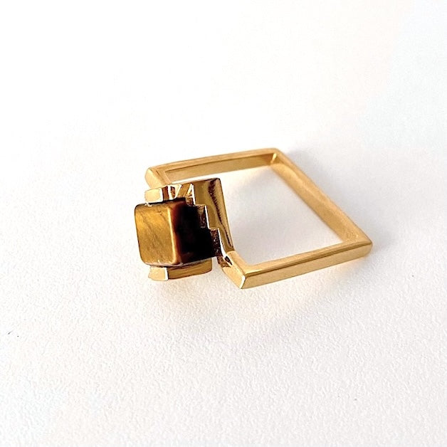 Bague solitaire en vermeil anneau fin carré. Son design audacieux intègre un cube en Oeil de tigre enchâssé entre deux éléments en forme d'escalier.