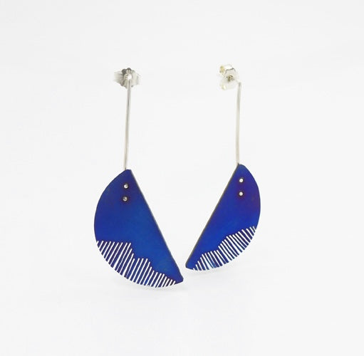Boucles pendantes composées d'un demi-cercles de titane bleui dont une partie est sciée comme des lamelles et suspendu à une tige droite en argent. 