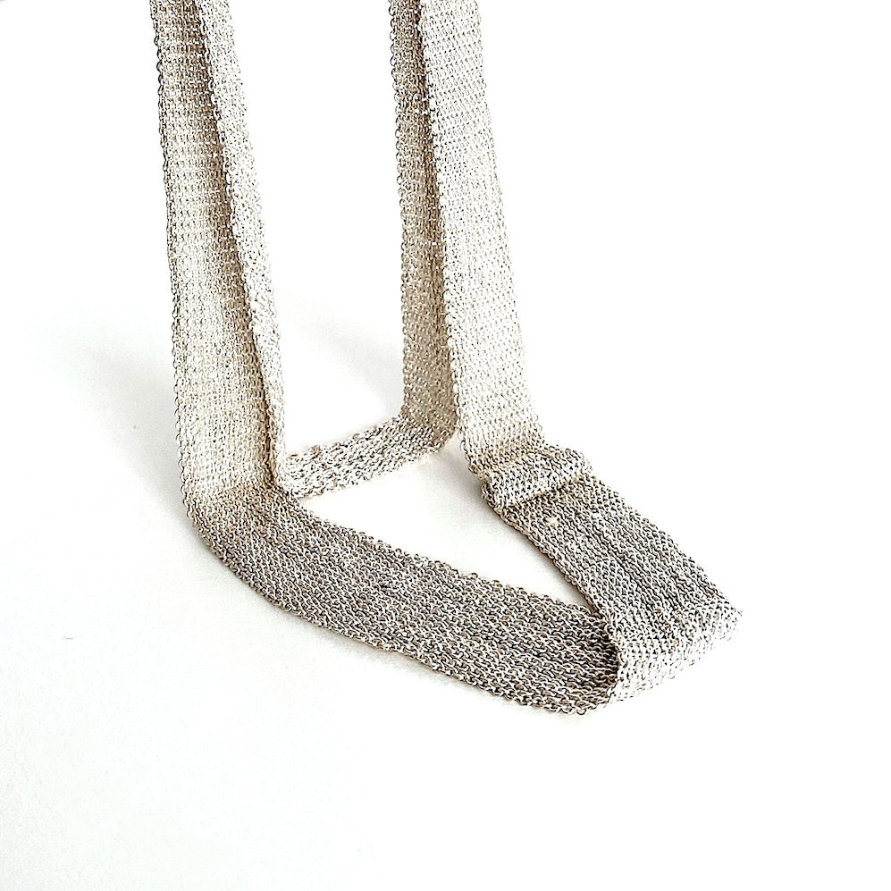 Long collier, composé de chaîne d'argent et fil de soie en forme de ruban dégradé, présenté en double.