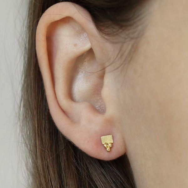 Puces d'oreilles or jaune 18 carats formes carrées ornées de 3 perles d'or. Bijoux portés.