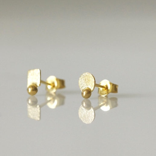 Puces d'oreilles or jaune asymétriques , ronde et carrée ornées d'une perle d'or.Vue de profil.