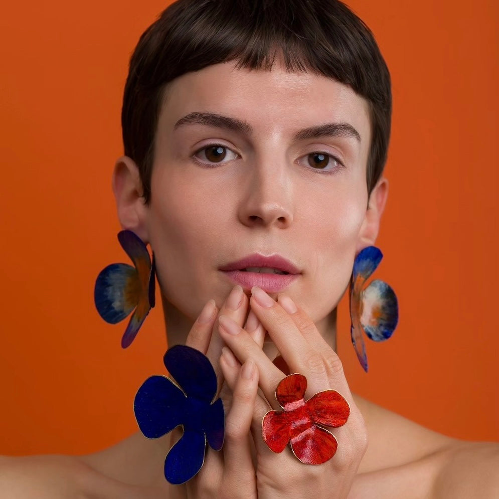 Boucles d'oreilles et bagues fleurs colorées rouge et bleu. Bijoux portés.