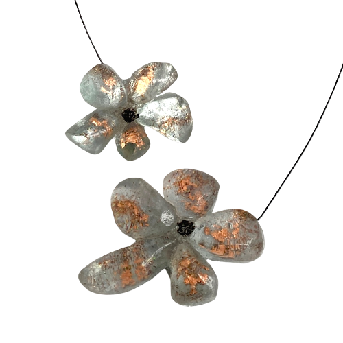 Collier en résine gris clair avec reflets irisés cuivre, cable acier noir. Fermoir aimanté à l'avant inséré dans les fleurs.