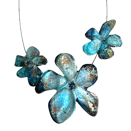 Collier 3 fleurs en résine bleu aux reflets irisés, cable acier noir. Fermoir aimanté à l'avant inséré dans les éléments.