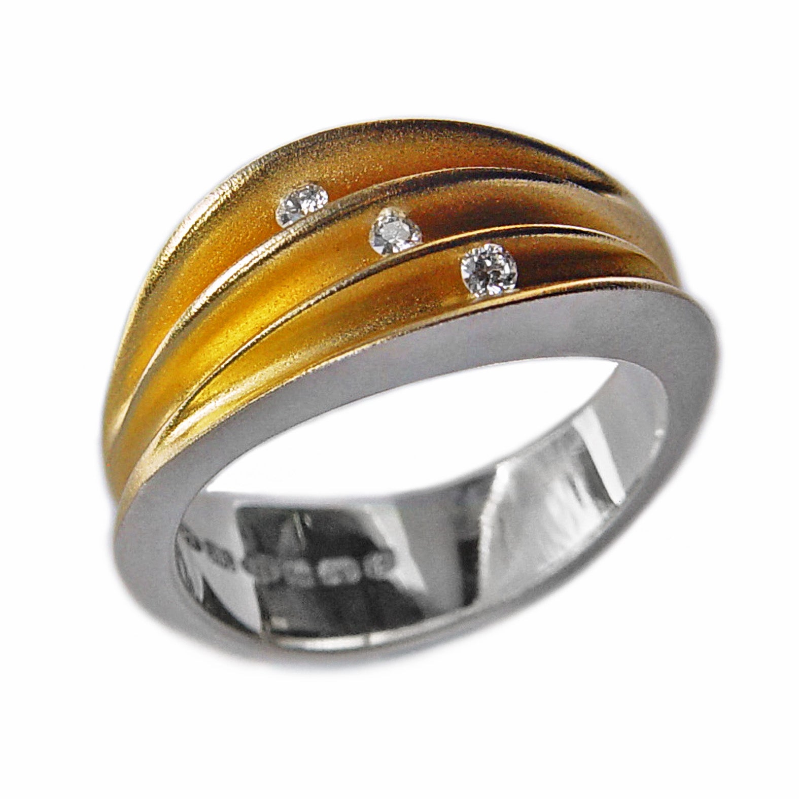 Bague argent ornée de 3 plis en forme de coquille, intérieur plaqué or 22 carats, 3 diamants sont sertis en diagonale dans les plis.