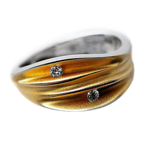Bague sculpturale en argent et diamants. Sur le dessus du bijou,  trois plis en argent plaqué or jaune, sertis de 2 diamants en diagonale .