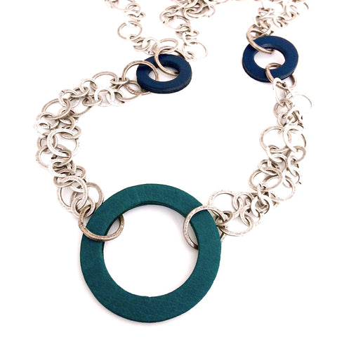 Long sautoir double chaîne métallique et cercles de cuir bleu et vert de différentes tailles.