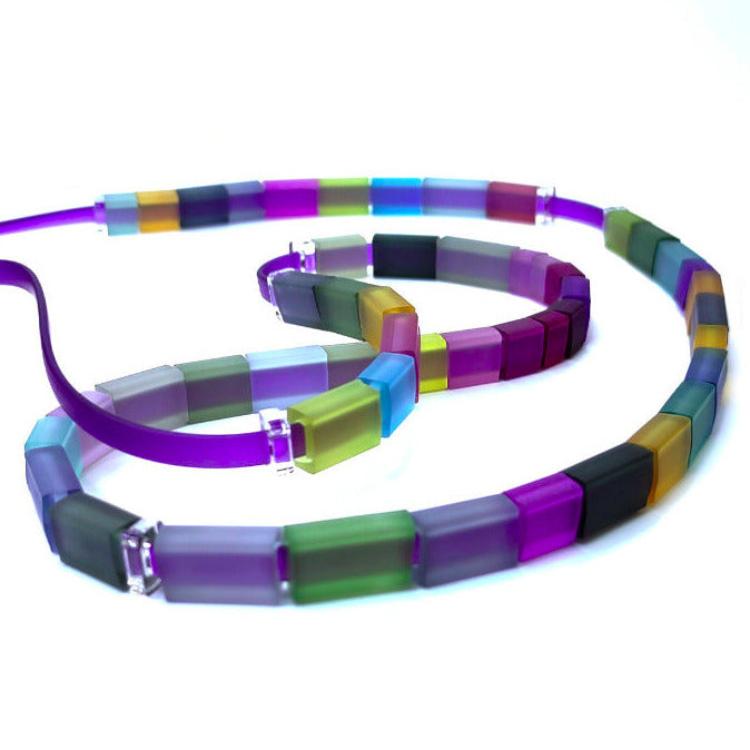 Long collier en caoutchouc réglable composé de petits rectangles aux couleurs joyeuses. longueur 120 cm.
