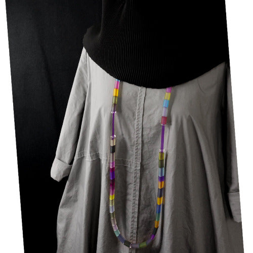 Long collier en caoutchouc réglable composé de petits rectangles aux couleurs pop, présenté sur buste mannequin