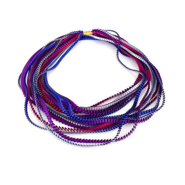 Long sautoir coloré composé de huit bandes de satin plissé violet, silver, fushia et bleu royal reliées les unes aux autres par un lien de coton jaune