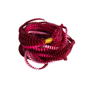 Long sautoir coloré composé de huit bandes de satin plissé fushia, rose et bordeaux reliées les unes aux autres par un lien de coton jaune.