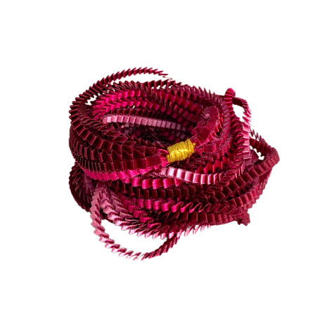 Long sautoir coloré composé de huit bandes de satin plissé fushia, rose et bordeaux reliées les unes aux autres par un lien de coton jaune.