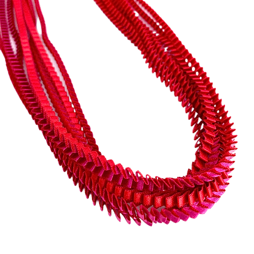 Long collier coloré composé de huit bandes de satin plissé rouge,fushia reliées les unes aux autres par un lien de coton jaune 
