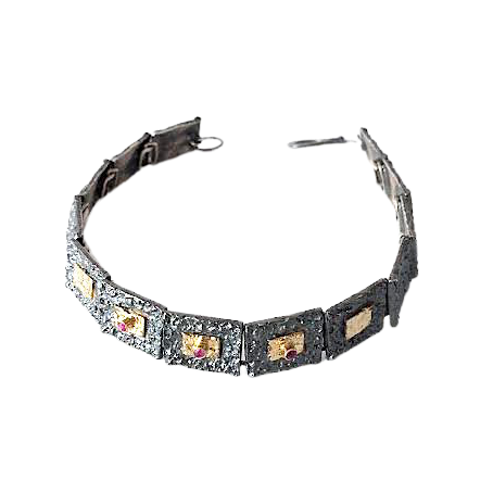 Bracelet articulé argent patiné, composé de 13 éléments rectangulaires, ornés de 5 rectangles or jaune et 3 rubis sertis. 