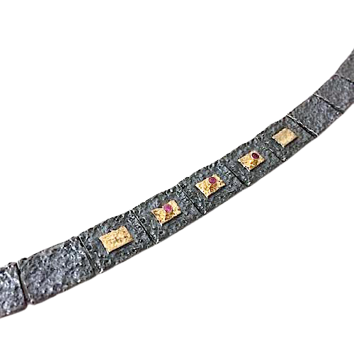 Bracelet articulé argent patiné, composé de 13 éléments rectangulaires, ornés de 5 rectangles or jaune et 3 rubis sertis. 