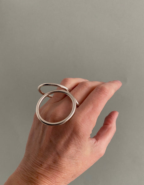 Bague géométrique en argent composée d'un cercle et d'un ovale relié par un anneau central à porter sur différents doigts