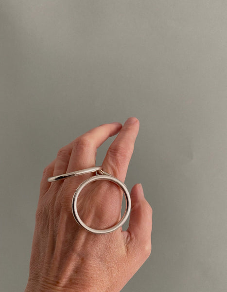 Bague géométrique en argent composée d'un cercle et d'un ovale relié par un anneau central à porter sur différents doigts