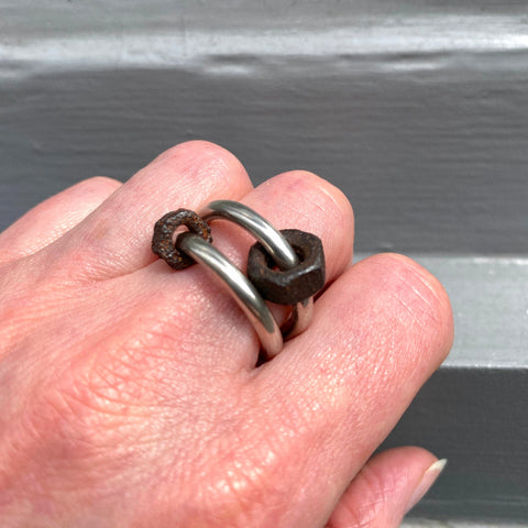Deux anneaux rond en argent forgé avec écrou de différentes tailles en acier rouillé.