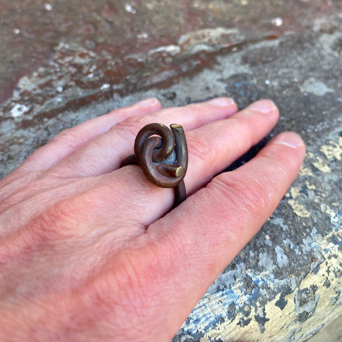 Bague avec noeud sur le dessus en titane forgé, patine effet bois, reflets dorées. pièce 2019