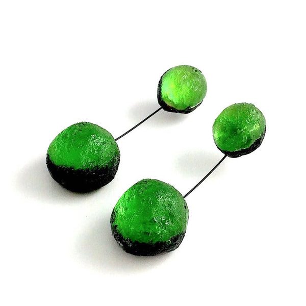 Boucles d'oreilles constituées de 2 sphères en résine irisée verte, reliées par un cable noir. 