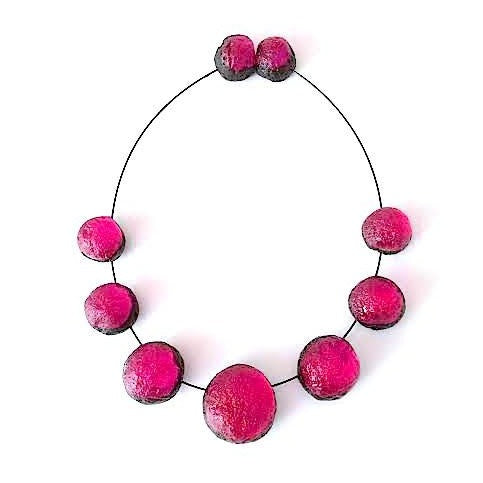 Collier composé de 7 sphères rose fushia assemblées sur un cable noir, fermoir aimanté.
