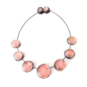 Collier composé de 7 sphères de rose pâle assemblées sur un cable noir, fermoir aimanté.