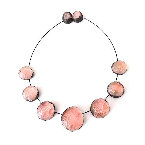 Collier composé de 7 sphères de rose pâle assemblées sur un cable noir, fermoir aimanté.
