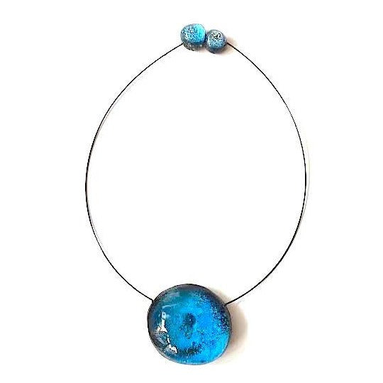 Collier rond en résine bleu clair assemblé sur un cable fin et solide. fermoir aimanté. fait main et unique