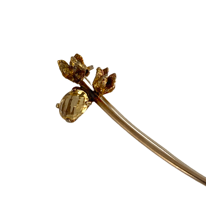 Broche forme branchette en argent patiné doré, ornée de 2 fleurs et d'un quartz jaune facetté.